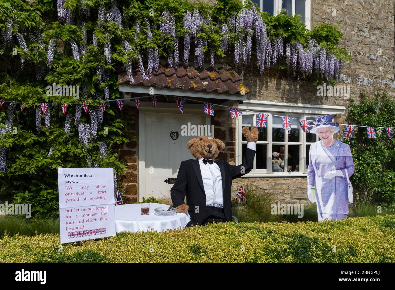 VE Day 75. Jahrestag im Dorf Little Houghton, Northamptonshire, Großbritannien: Figuren von Winnie Bear und Queen Elizabeth in einem Garten Stockfoto