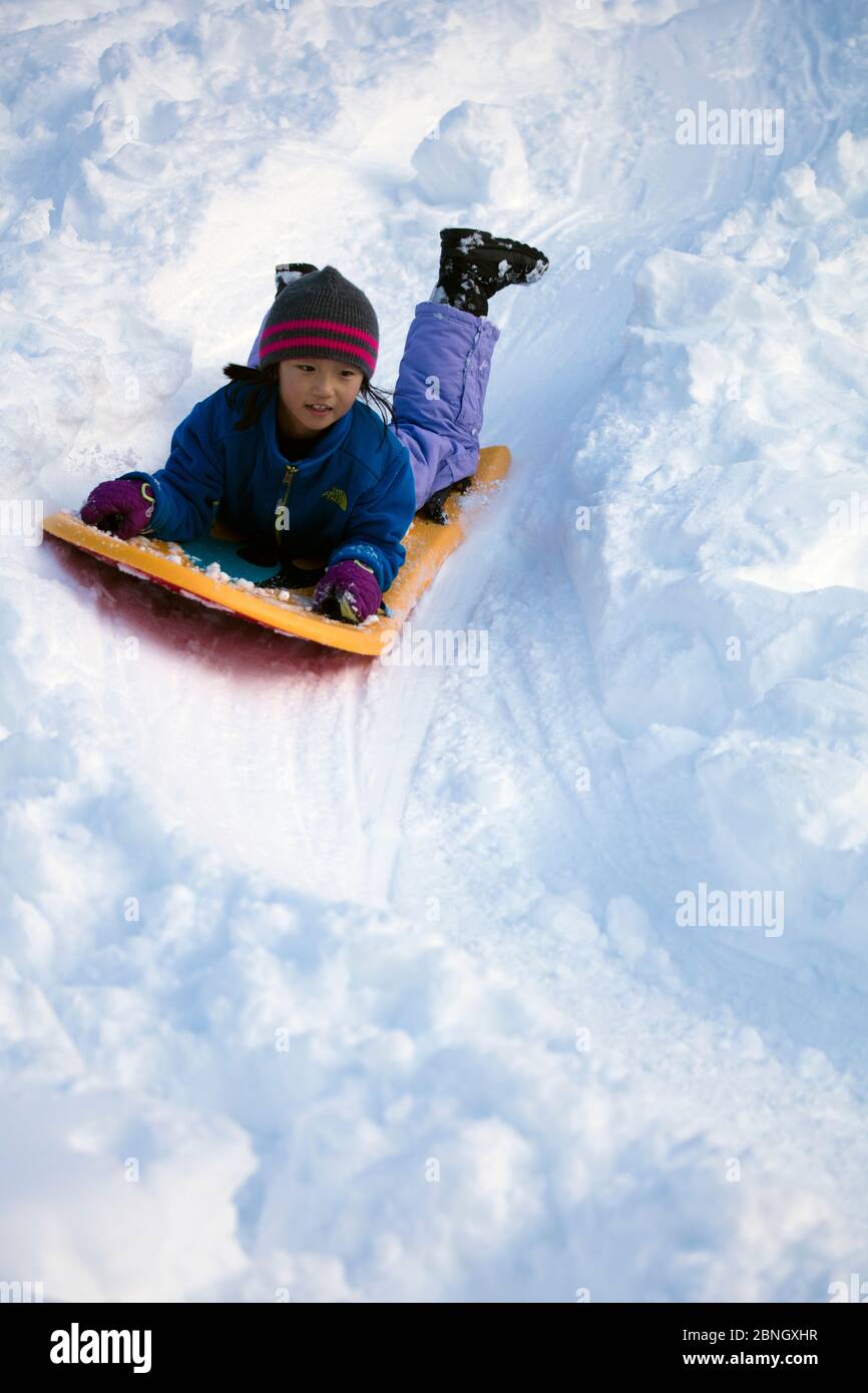 Kind spielt mit Schlitten im Schnee während Wintersturm Jonas, Washington DC, USA, Januar 2016 Stockfoto