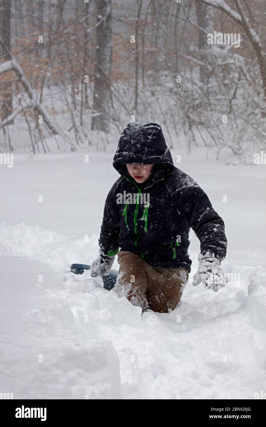 Kind spielt mit Schlitten im Schnee während Wintersturm Jonas, Washington DC, USA, Januar 2016 Stockfoto