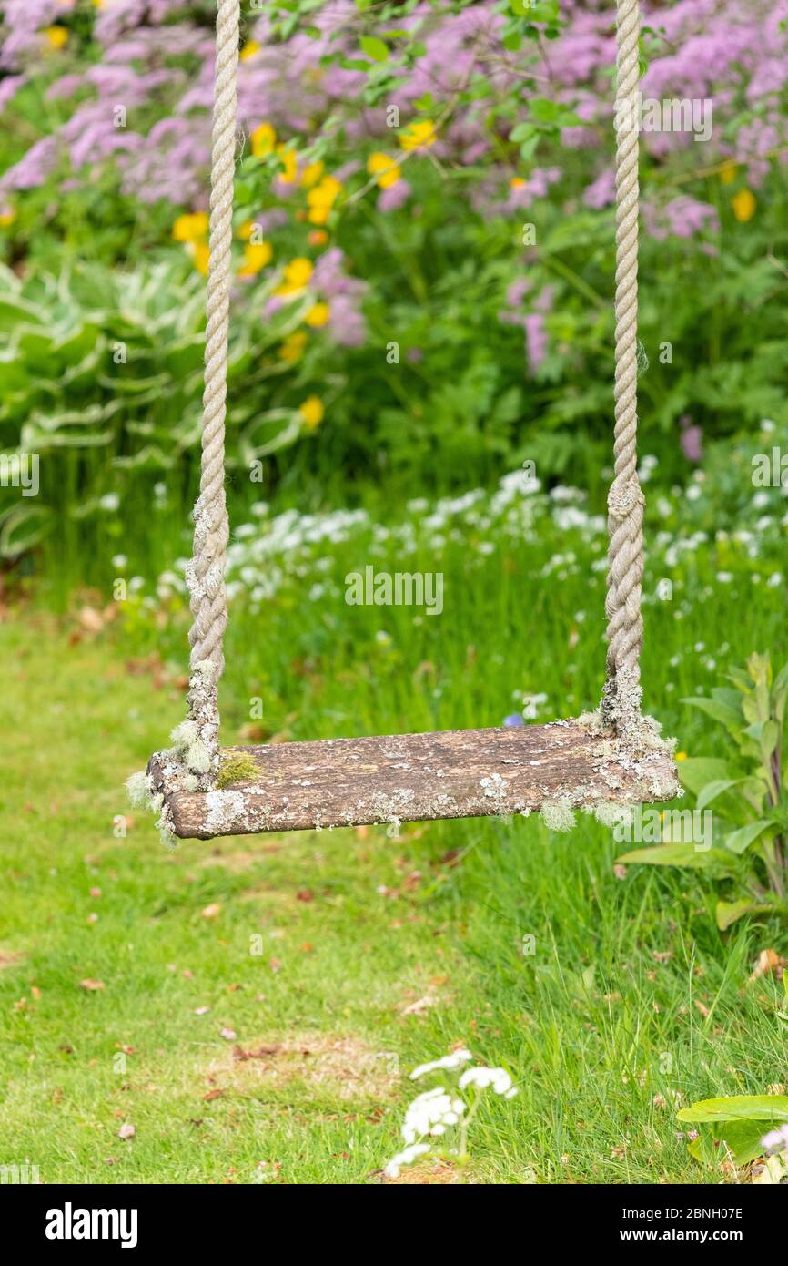 Holzgarten Schaukel mit Flechten in entspannter Familie und Wildlife Garten - Großbritannien bedeckt Stockfoto