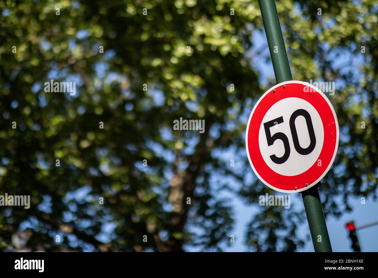 Düsseldorf, Deutschland. Mai 2020. Vor parkenden Autos auf einer Hauptstraße befindet sich ein Verkehrsschild, das die Geschwindigkeit auf 50 km/h begrenzt. Bundesverkehrsminister Scheuer (CSU) will strengere Vorschriften über Fahrverbote bei zu schnellem Fahren aufheben. Das Hauptproblem ist die Regel, dass Fahrverbote jetzt seit einem Monat bestehen, wenn eine Person 21 Stundenkilometer zu schnell in Städten oder 26 km/h außerhalb von Städten fährt. Diese Regelung sei "unverhältnismäßig", sagte das Ministerium. Bild: Marcel Kusch/dpa/Alamy Live News Stockfoto