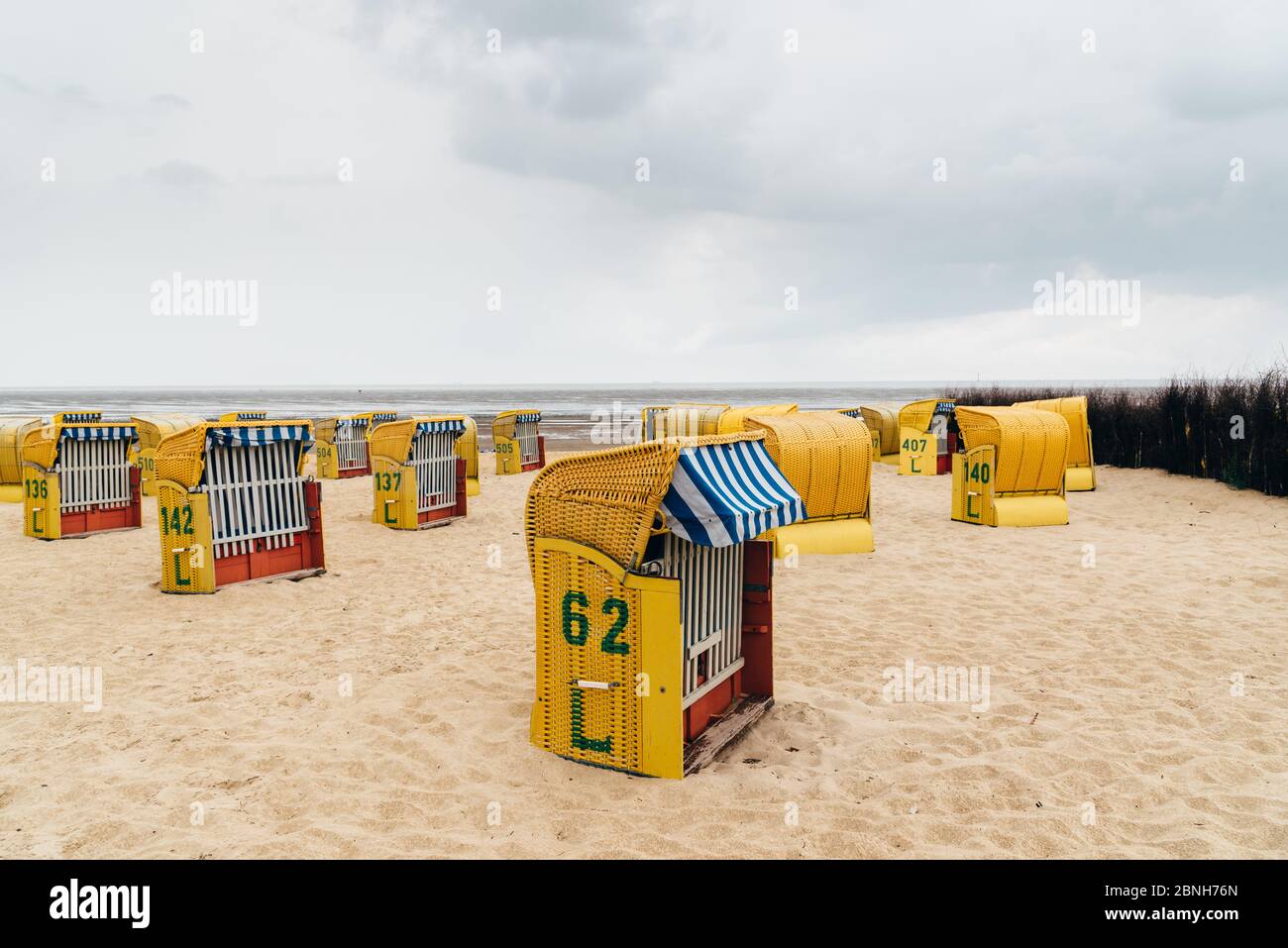 Sandstrand und typische Kapuzenliegen in Cuxhaven an der Nordseeküste ein bewölktes Sommerfest. Deutschland Stockfoto