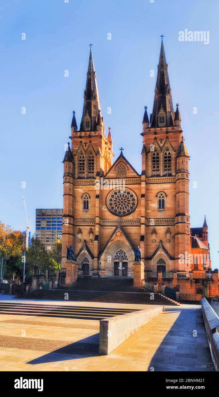 Historisches Gebäude der alten gotischen Kathedrale in der Stadt Sydney bei Sonnenaufgang gegen blauen Himmel aus Sandsteinfliesen mit hohen Türmen gemacht. Stockfoto