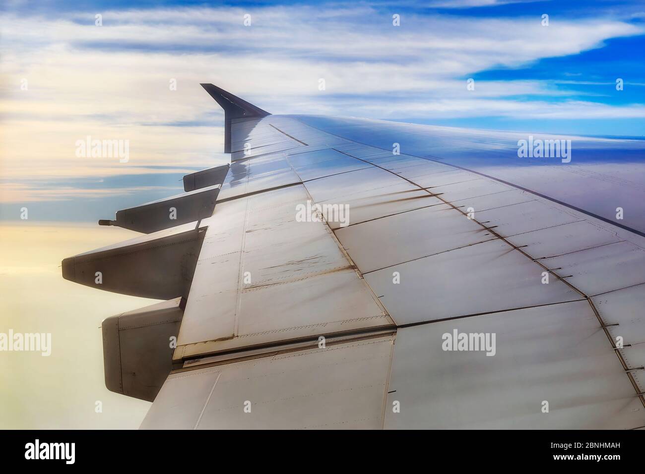 Leichtmetall-Airplain Flügel gegen blauen Himmel hoch in der Erdatmosphäre - Fernreisen Industrie und Luftfahrt. Stockfoto