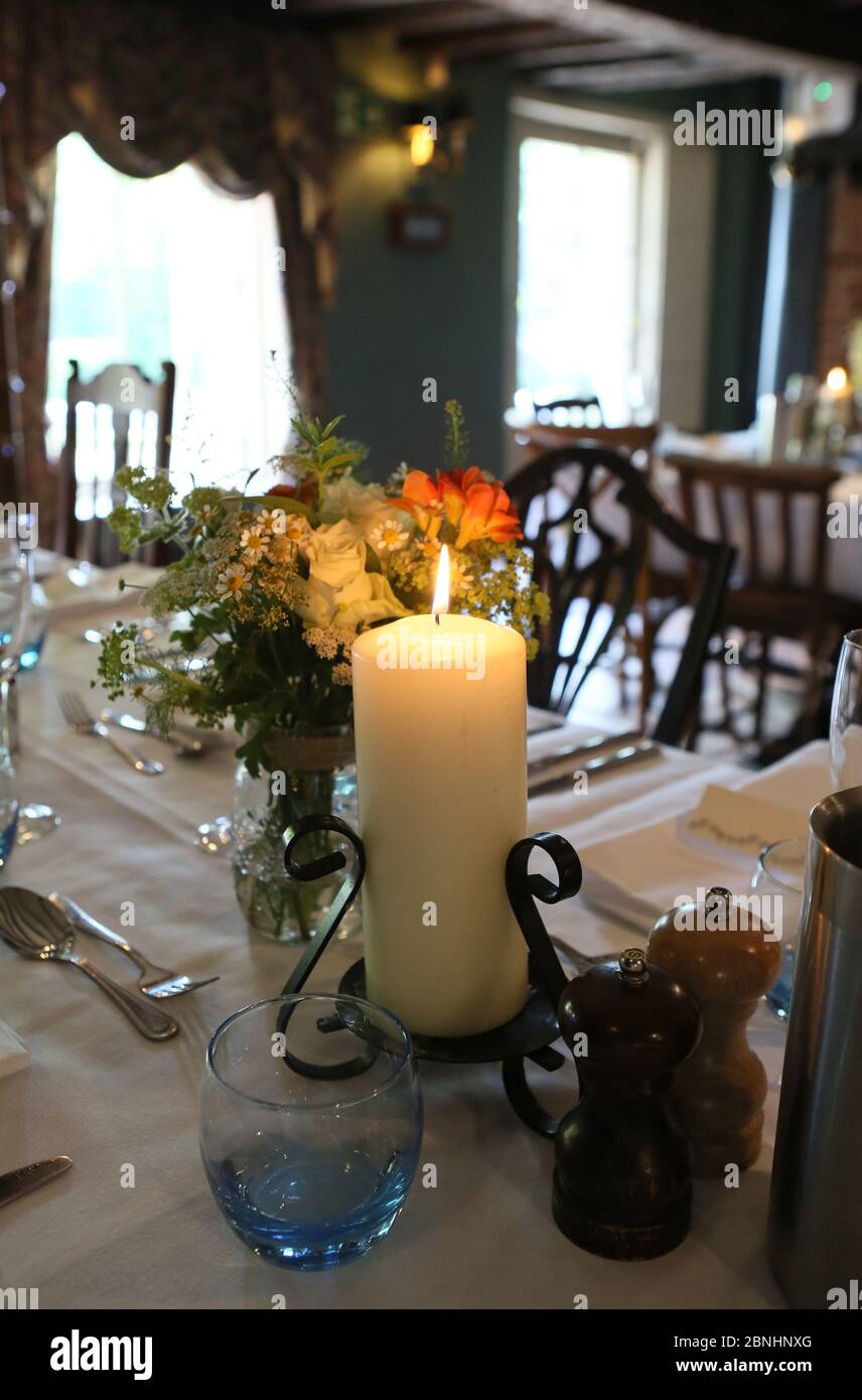 Eine extravagante Hochzeitszeremonie findet in einem Hotel in Surrey England statt. Üppige Kerzen und Geschirr schmücken die Rezeptionstische Stockfoto