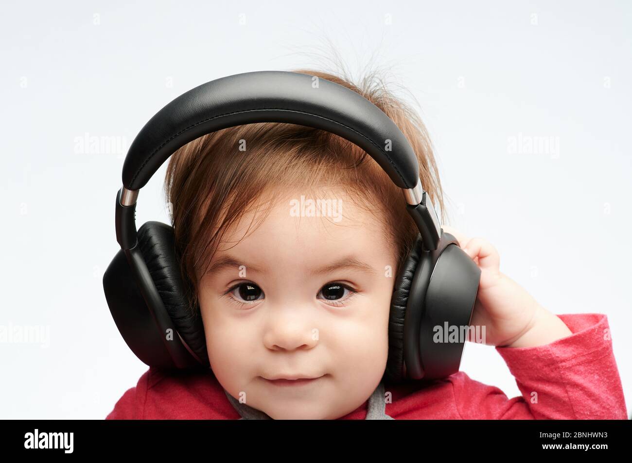 Lustiges Porträt des Babys mit Kopfhörern isoliert auf weißem Hintergrund Stockfoto