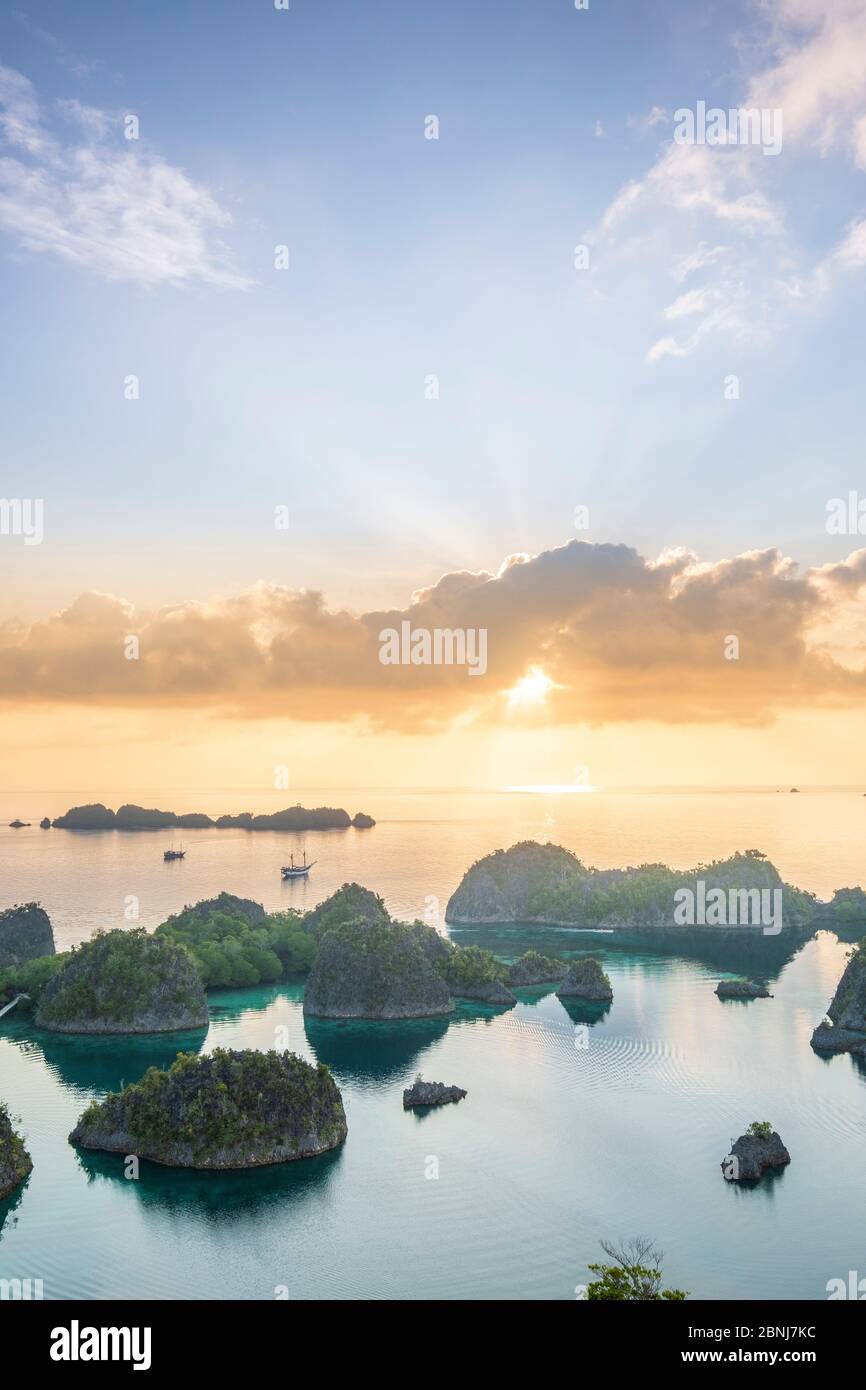 Blick über eine Bucht von Inseln bei Sonnenaufgang vom Piaynemo Aussichtspunkt, Raja Ampat, West Papua, Gewürzinseln, Indonesien, Südostasien, Asien Stockfoto
