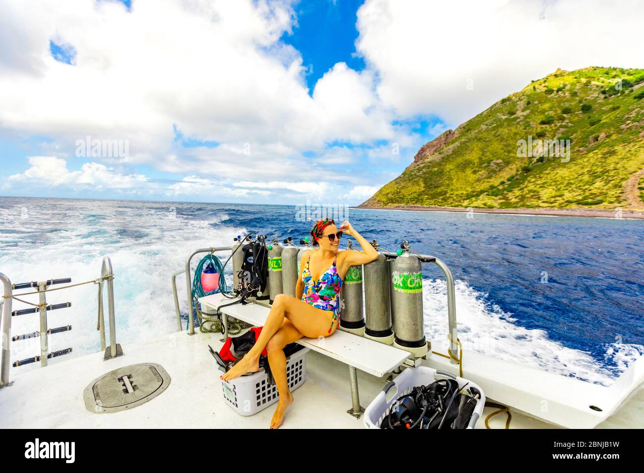 Frau, die die Sehenswürdigkeiten von einem Boot auf dem Wasser auf Saba Island, Niederländische Antillen, Westindien, Karibik, Mittelamerika Stockfoto
