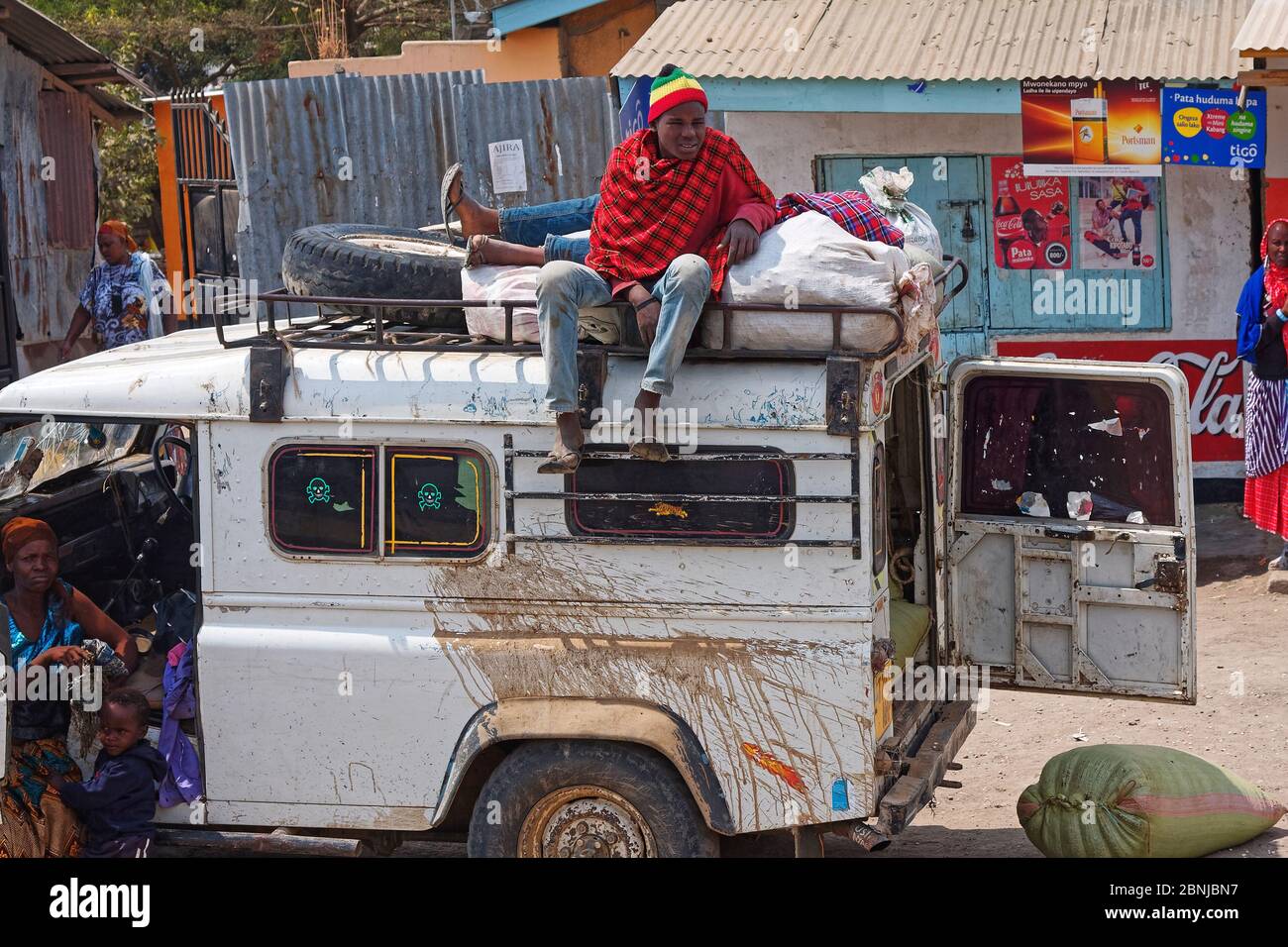 Alter LKW, weiß, verprügelt, schmutzig, zwei Männer auf dem Dachträger ruhen, Frau, Junge, Lebensstil, Menschen, Geschäft, Afrika; Arusha; Tansania Stockfoto