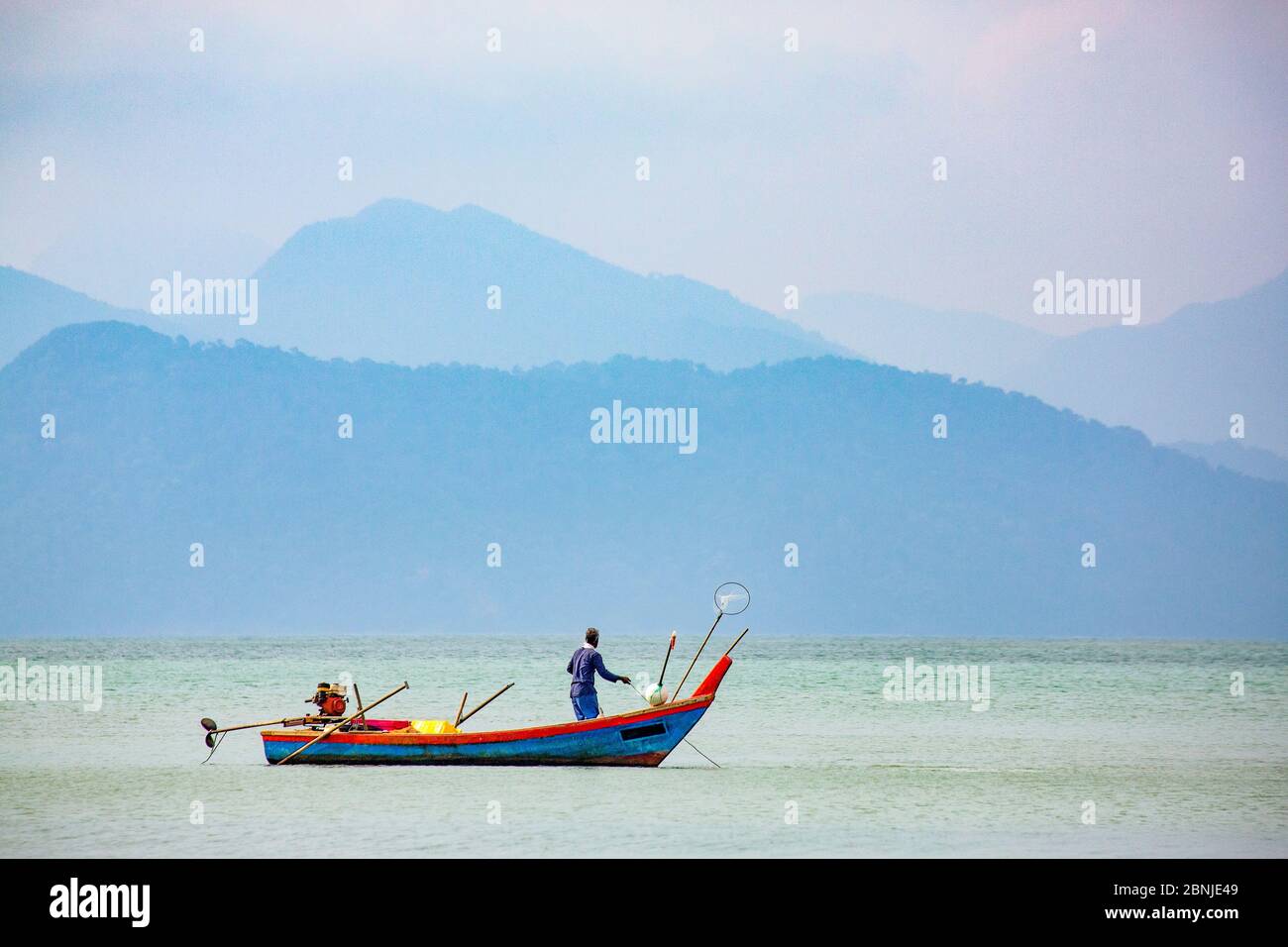Fischer auf kleinem Boot, Straße von Malacca mit Thai-Insel Ko Tarutao von Datai Bay Beach (Pantai Teluk Datai), Andamanensee, Malaysia, Südosten Stockfoto