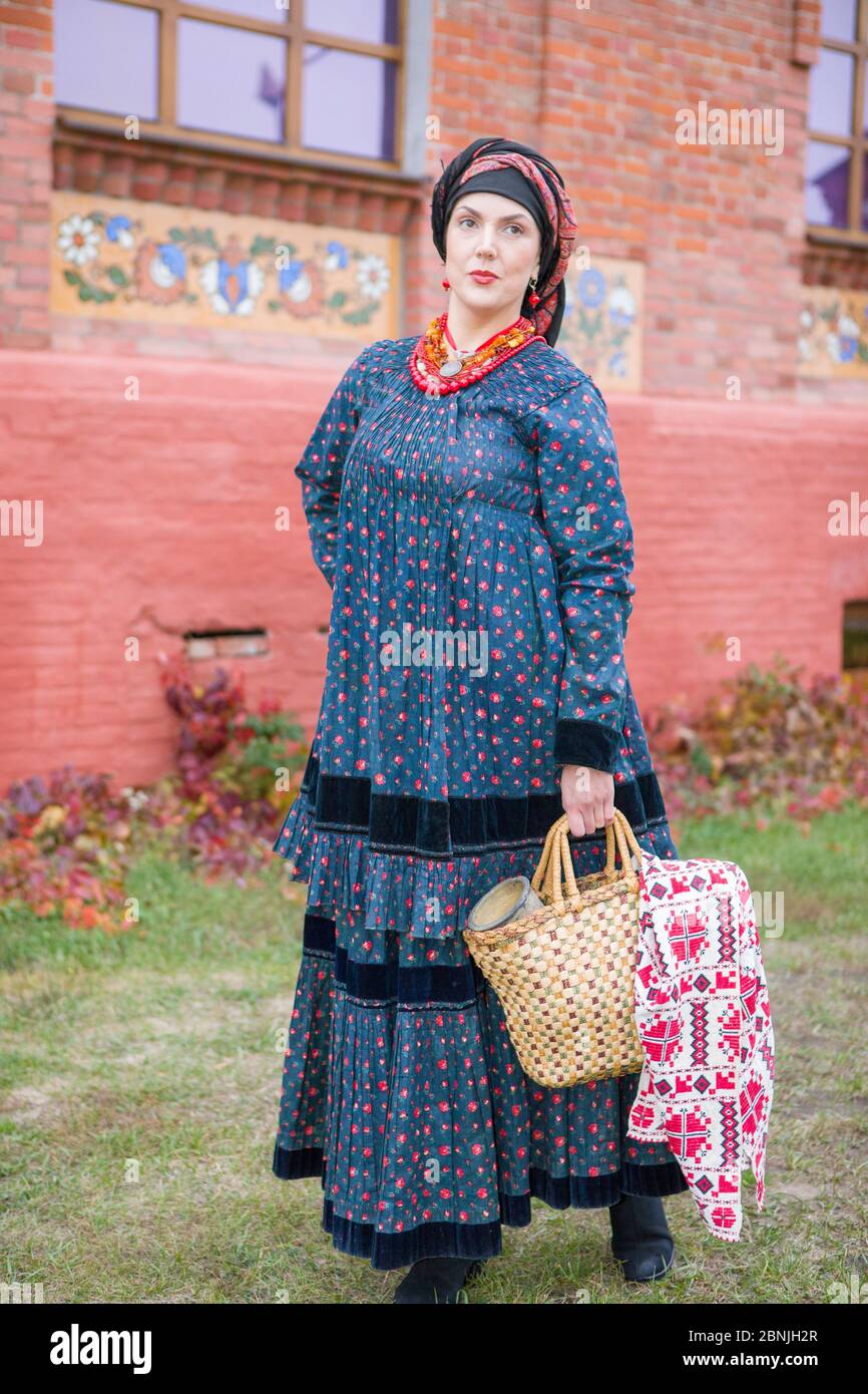 Frau mit einem Korb in Retro-Kleidung des 19. Jahrhunderts. Antike Kleidung aus dem späten 19. Jahrhundert. Schönes Kleid und Rock auf einer Frau. Perlen und Stockfoto