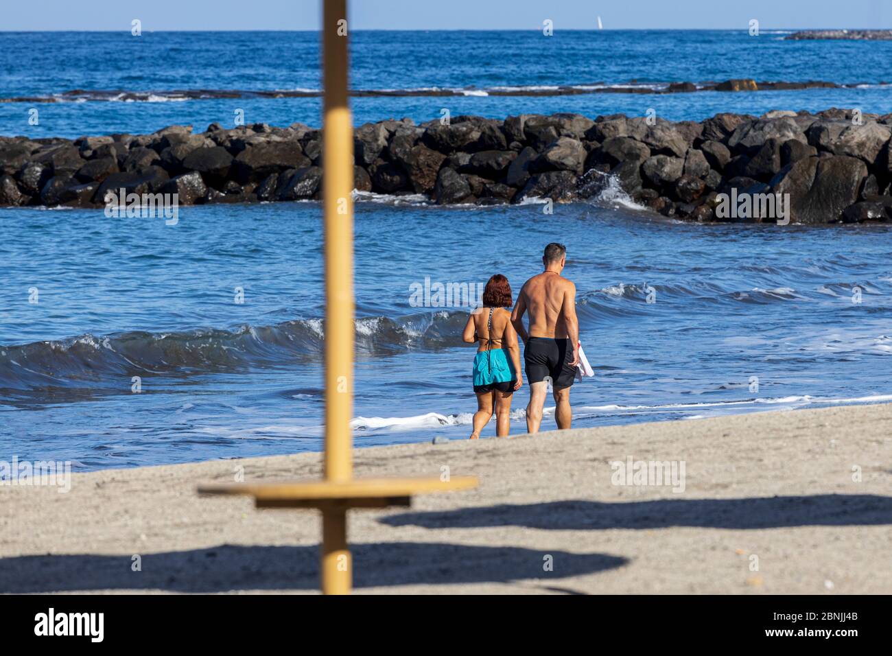 Costa Adeje, Teneriffa, Kanarische Inseln, Spanien. 15 Mai 2020. Der Strand Playa Fañabe ist für begrenzte Sport- und Bewegungsangebote geöffnet. Wandern, Laufen sind erlaubt, aber kein Sonnenbaden, Wassersport oder Schwimmen unter der Deeskalation der Covid 19, Coronavirus Sperrung. Kinderwagen an der Küste. Stockfoto