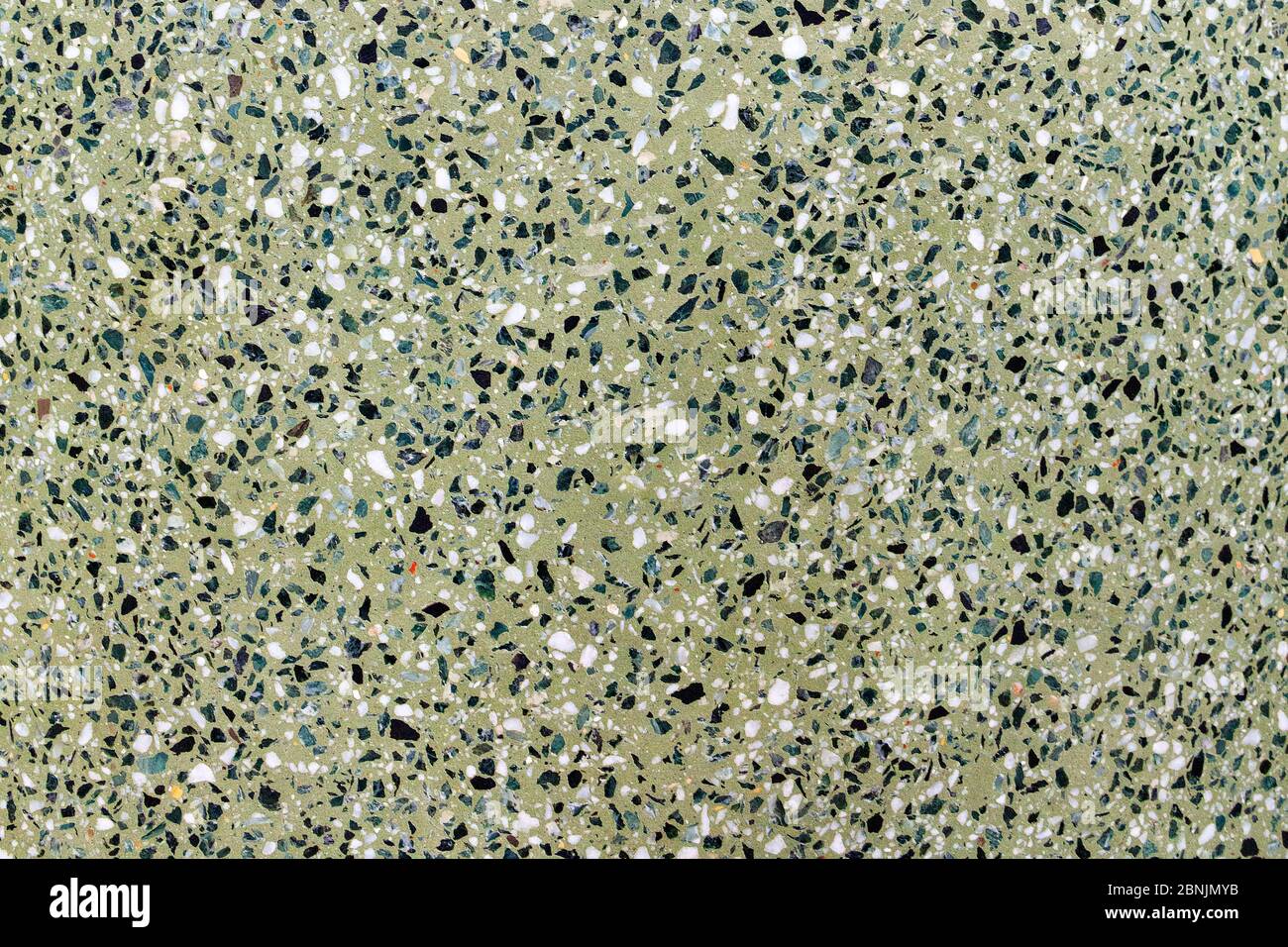 Die Textur des Mosaikbodens ist ein grüner Farbton aus Marmorspänen mit Natursteinen, Granit, Marmor, Quarz. Polierte Steinoberfläche. Stockfoto
