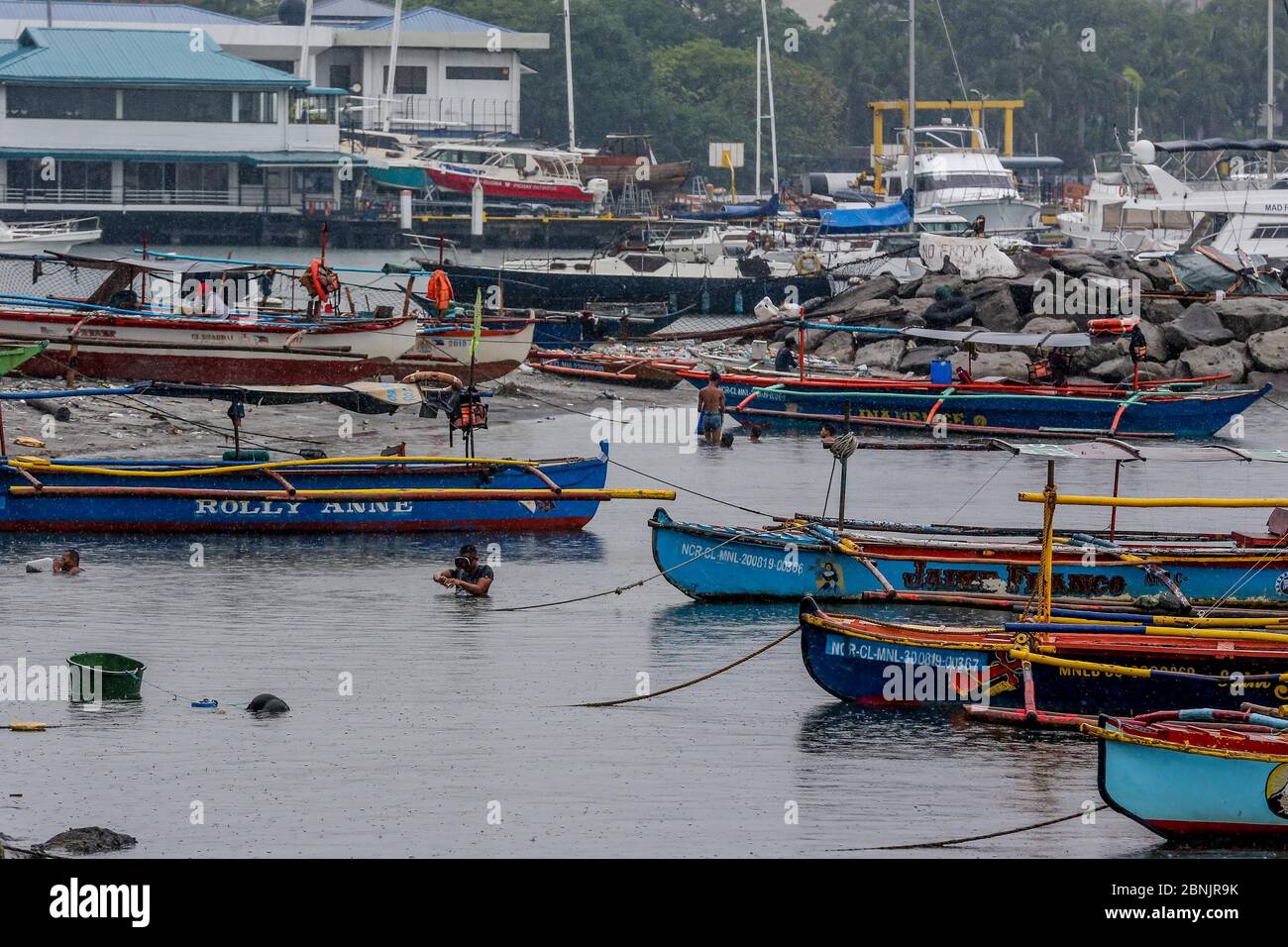 Manila. Mai 2020. Fischer schwimmen, um Krabben unter dem Regenguss zu fangen, der am 15. Mai 2020 vom Taifun Vongfong in Manila Bay auf den Philippinen gebracht wurde. Der Taifun Vongfong riss am Donnerstag um 12:15 Uhr Ortszeit in der östlichen Provinz Samar der zentralen Philippinen Dächer ab und schüttelte Bäume, wie die Behörden sagten. Vongfong ist der erste Taifun, der in diesem Jahr die Philippinen übertatteln wird, während das Land mit den Folgen der COVID-19-Pandemie zugeht. Quelle: Rouelle Umali/Xinhua/Alamy Live News Stockfoto