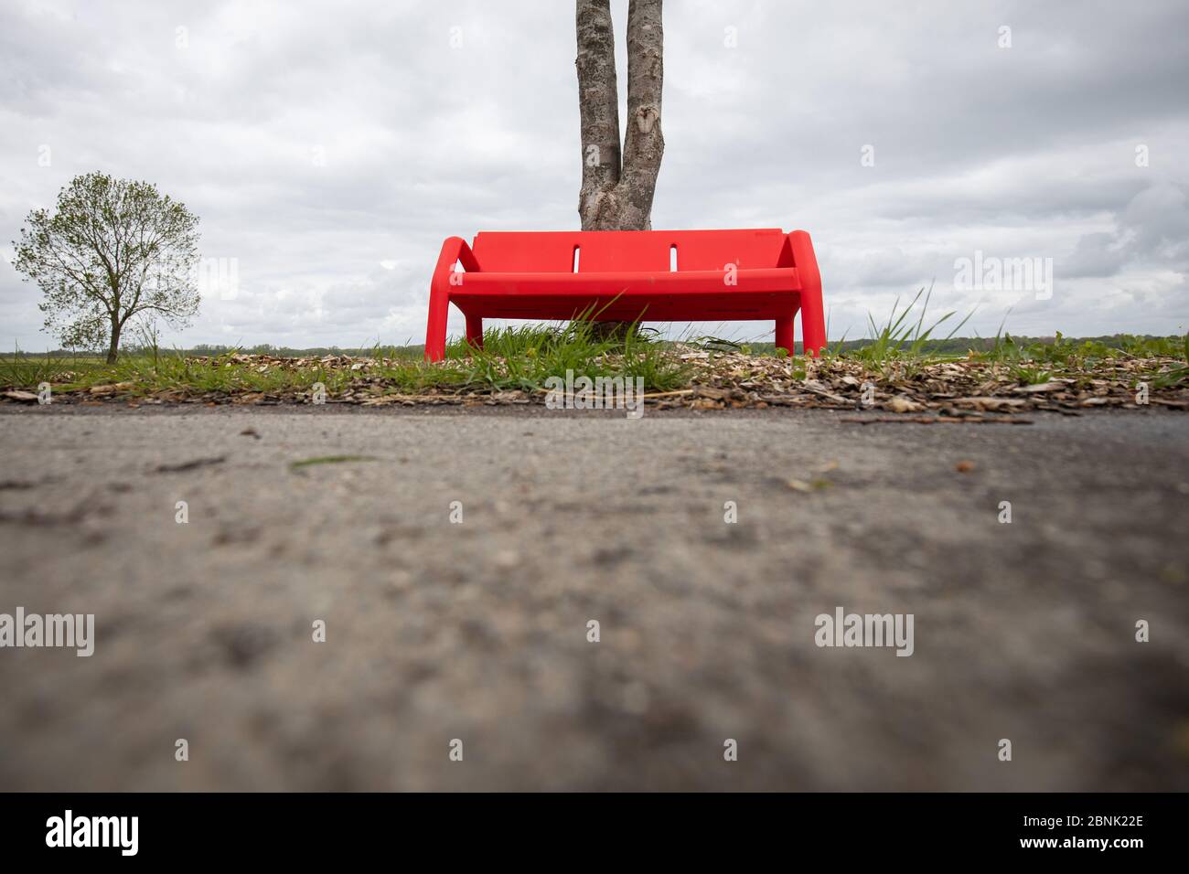 Steinburg, Deutschland. Mai 2020. Eine rote Bank steht auf einer Landstraße neben einer Haltestelle für den Schulbus. Kredit: Christian Charisius/dpa/Alamy Live News Stockfoto