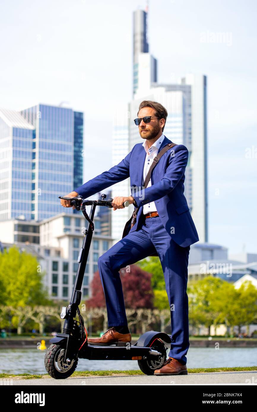 Mann im Anzug auf einem E-Scooter Stockfoto