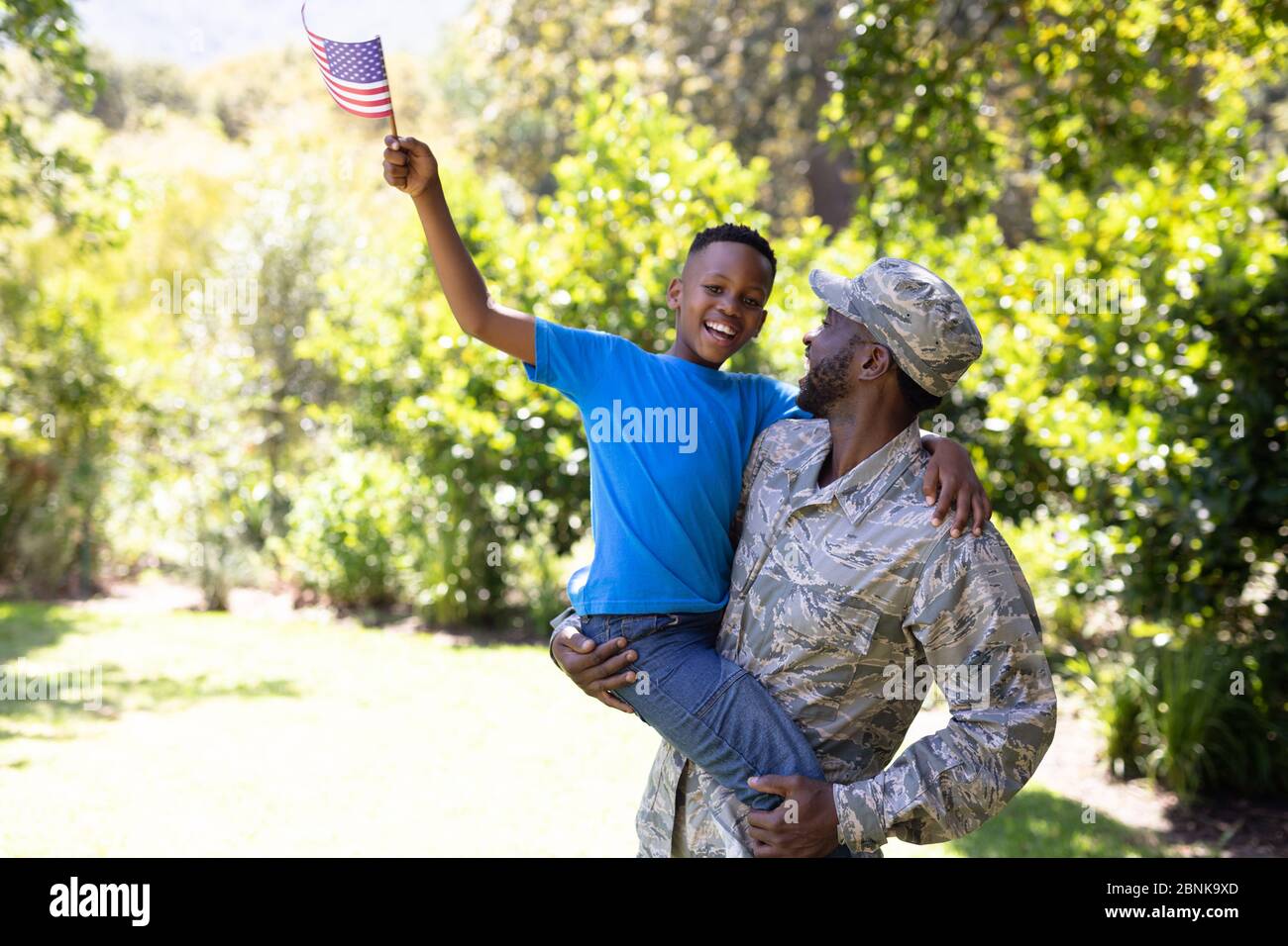 Afroamerikanischer Mann in Militäruniform, der seinen Sohn hält Stockfoto