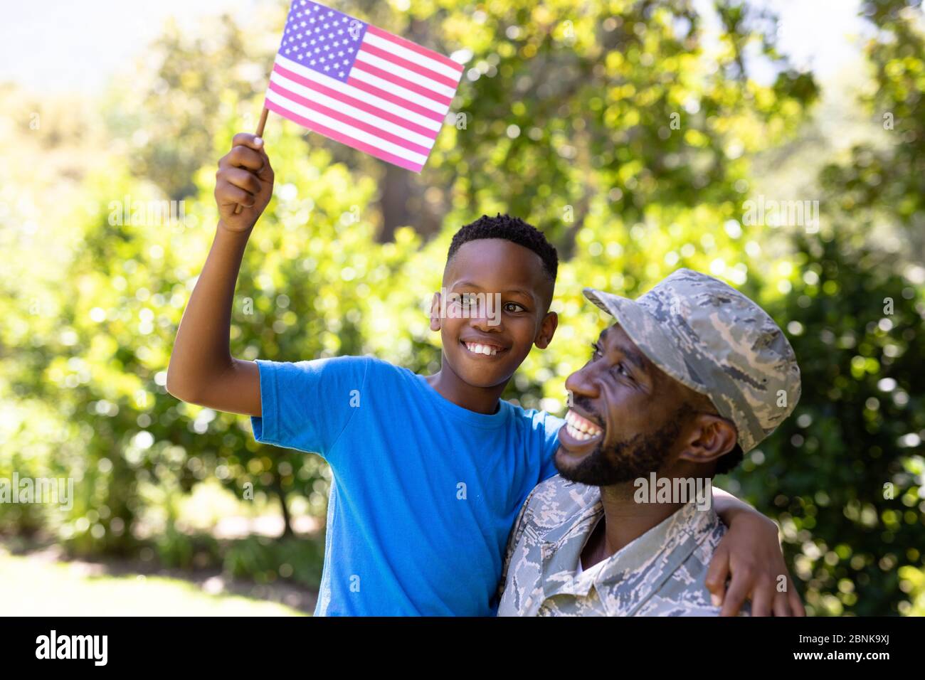 Afroamerikanischer Mann in Militäruniform, der seinen Sohn hält Stockfoto