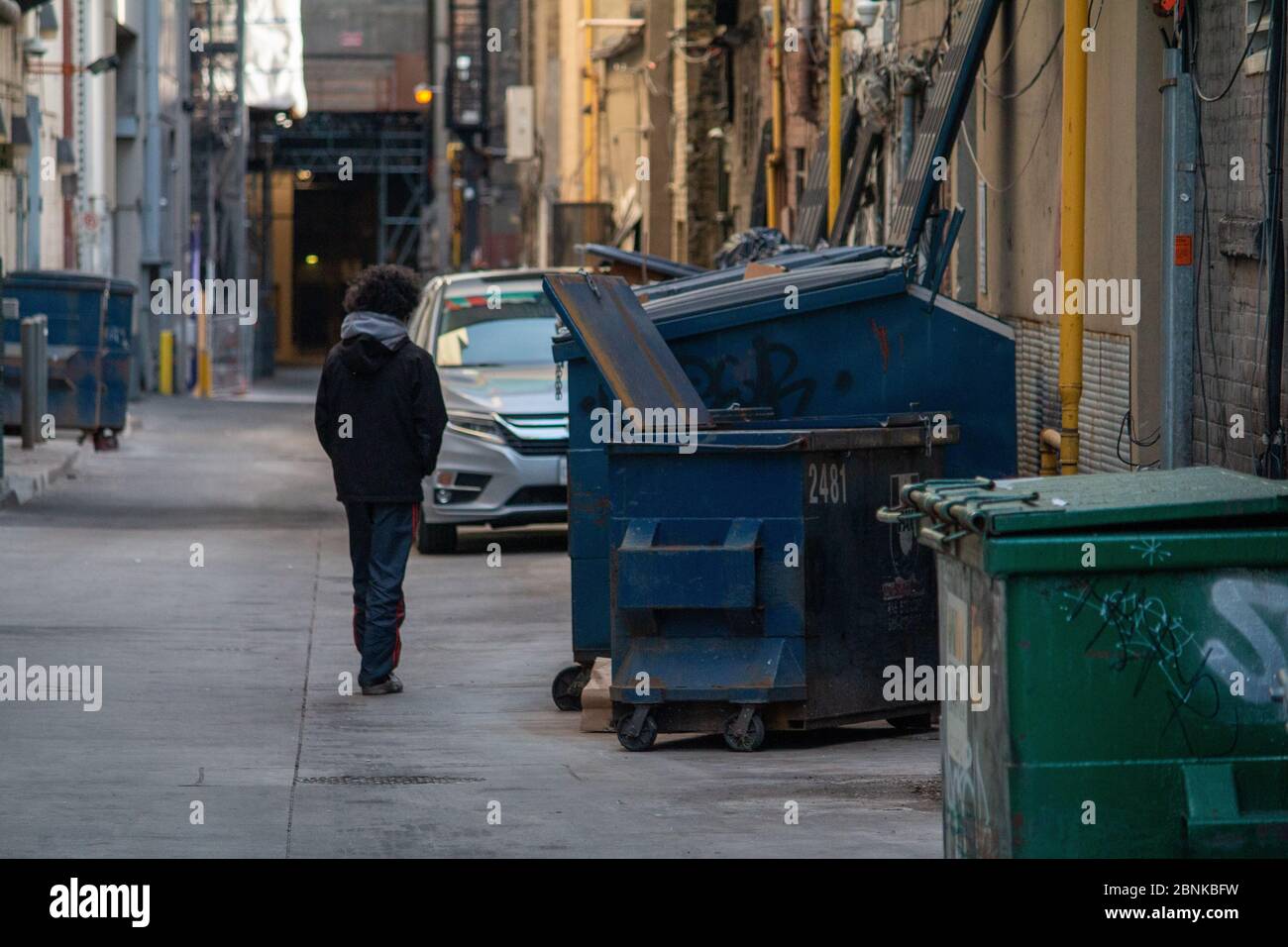 Obdachloser Mann, der während Covid-19 durch die Gasse auf dem Dundas Square spaziert Stockfoto