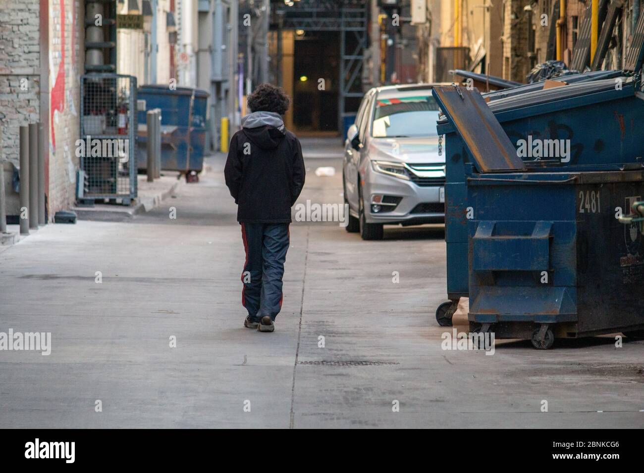 Obdachloser Mann, der während Covid-19 durch die Gasse auf dem Dundas Square spaziert Stockfoto