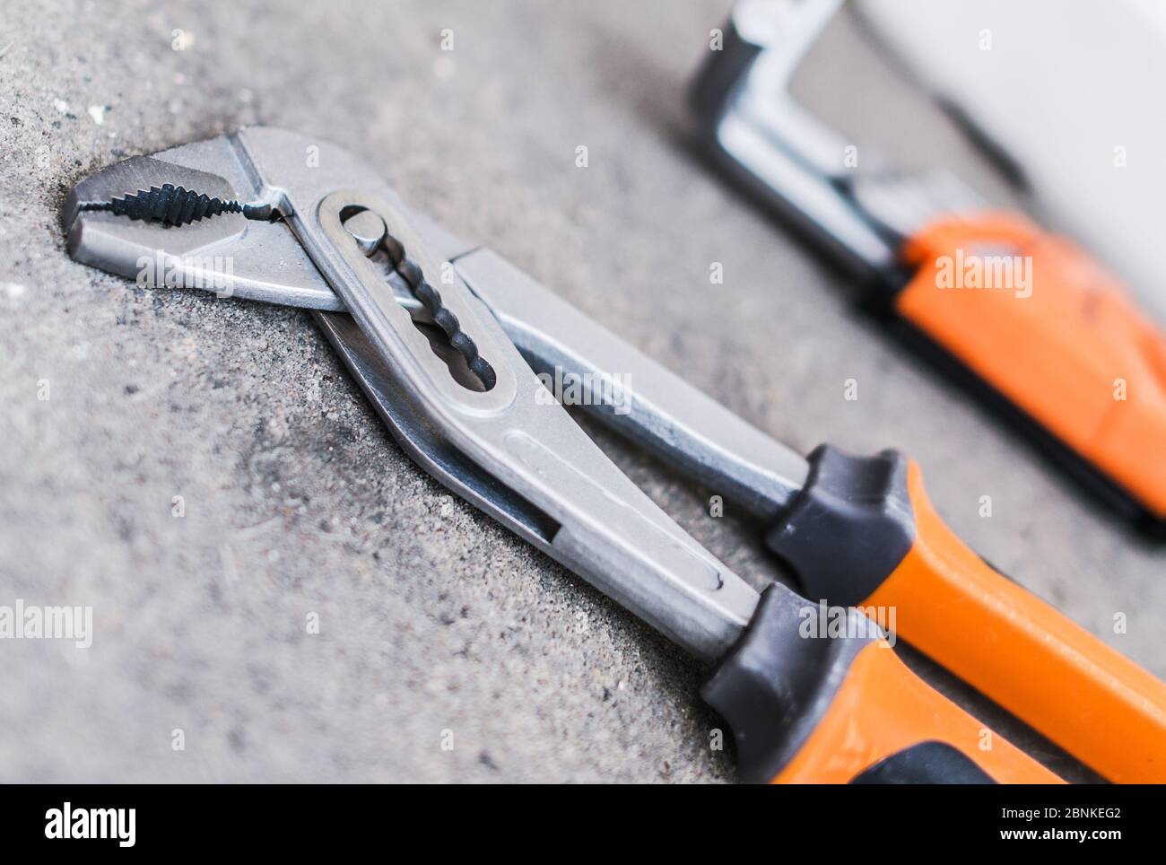 Nahaufnahme Der Metallzunge Und Der Zange Mit Orangefarbenen Und Schwarzen Griffen. Stockfoto