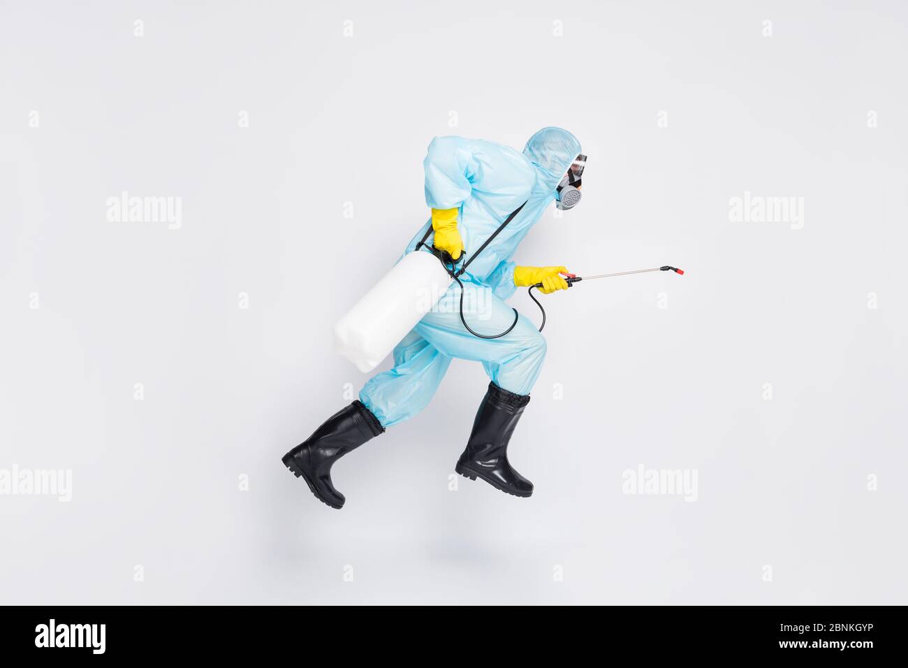 Ganzkörper-Profil Seite Foto Mann springen laufen Eile desinfizieren covid  Verbreitung Haus tragen weiß hazmat Anzug gelb Gummi Latex Handschuhe  Brille verwenden Sprayer Stockfotografie - Alamy