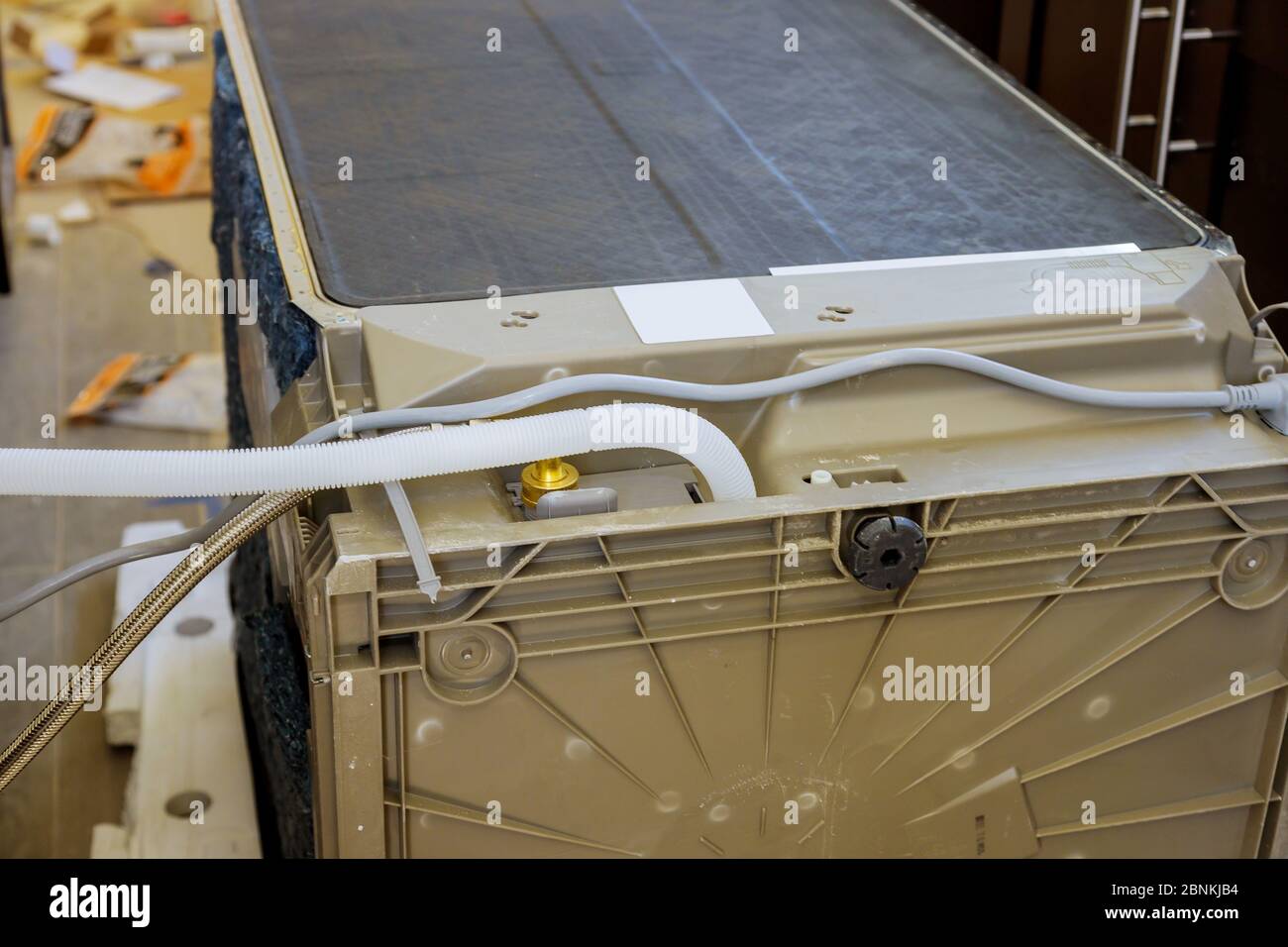 Klempner hat die Spülmaschine in der neuen Küche angeschlossen Stockfoto