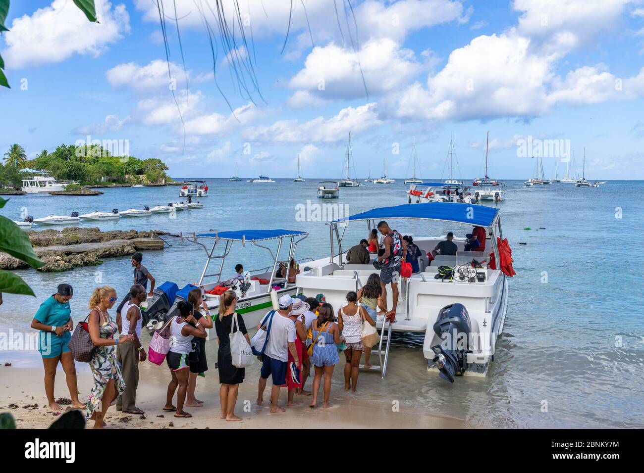 Amerika, Karibik, große Antillen, Dominikanische Republik, La Altagracia Provinz, Bayahibe, Touristen steigen an Bord eines Ausflugsboots am Strand von Bayahibe Stockfoto