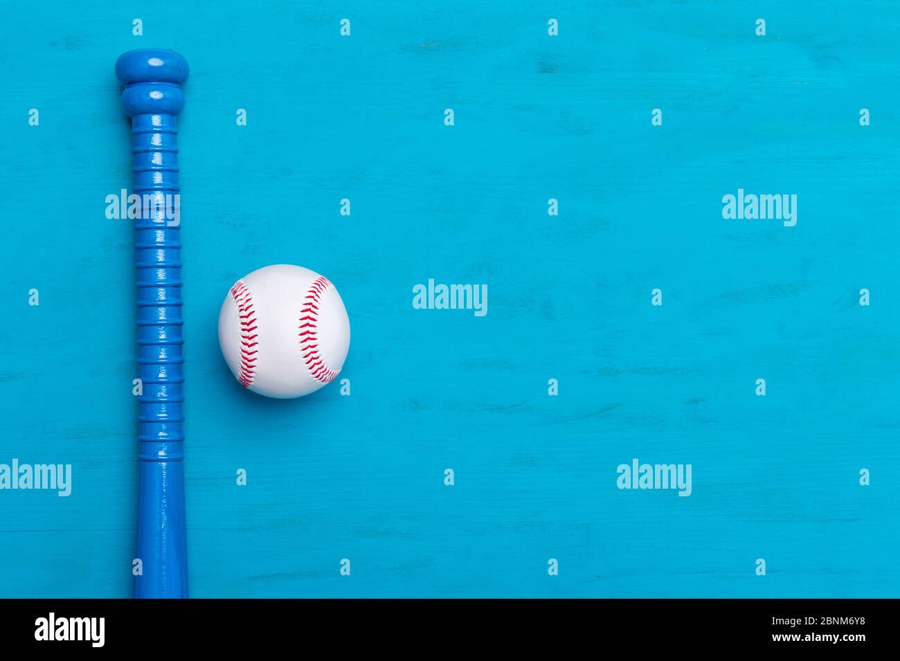 Blauer Baseballschläger und Ball auf blauem Holzhintergrund Stockfoto