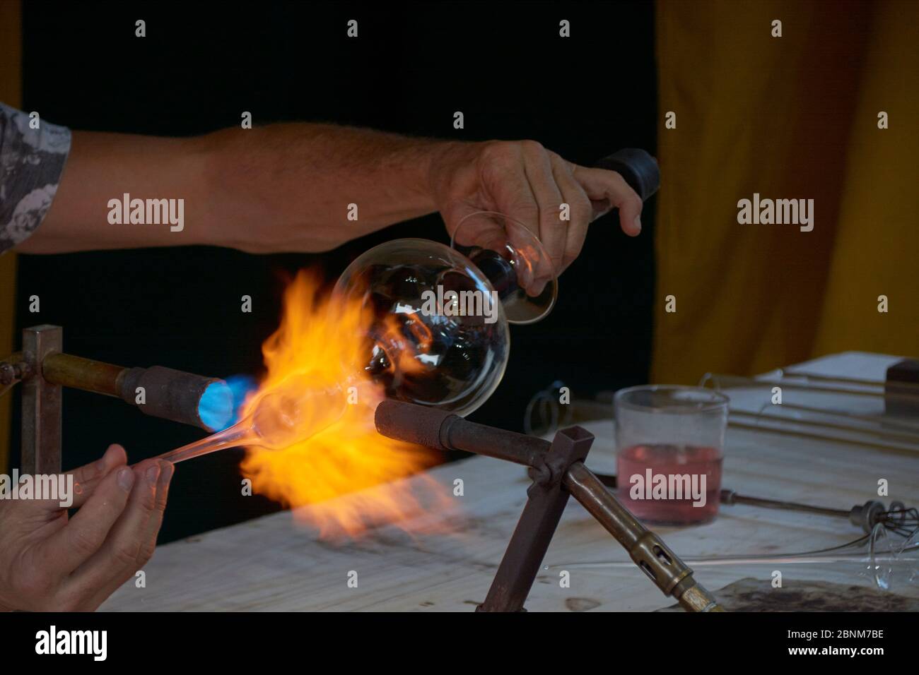 Geschickte Hände Formen heißes und gefährliches Glas. Alte Traditionen Stockfoto