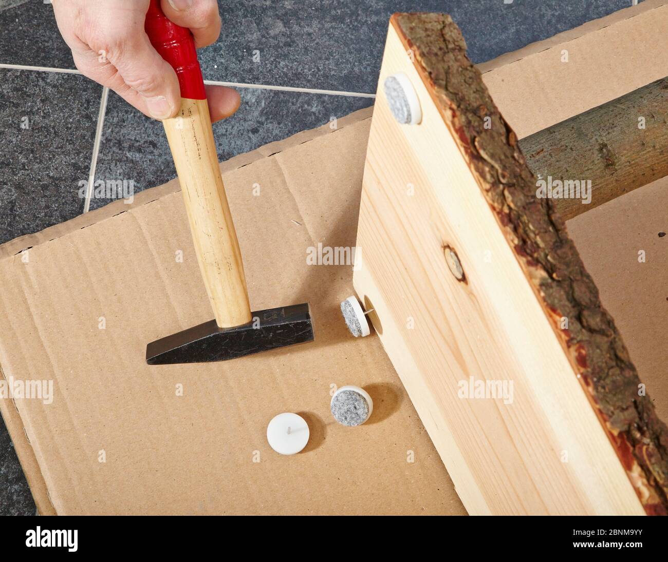 Bau eines Holzregals, Do-it-yourself-Produktion, Schritt für Schritt, Schritt 13 Anbringen von Filzkissen zum Schutz des Bodens und zum Schutz vor Verwackeln des Regals Stockfoto