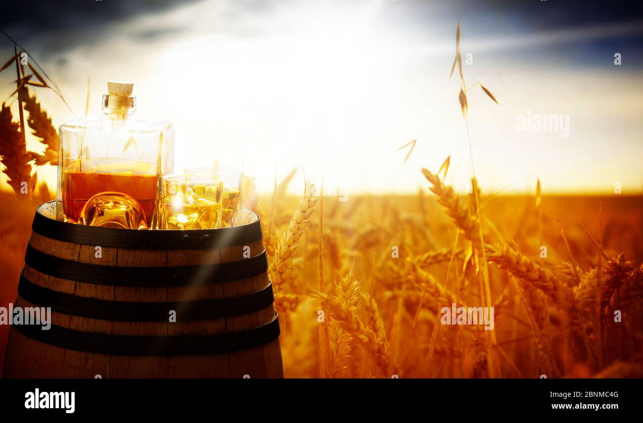 Whiskey Glasflasche am Feldrand im Sommer Stockfoto