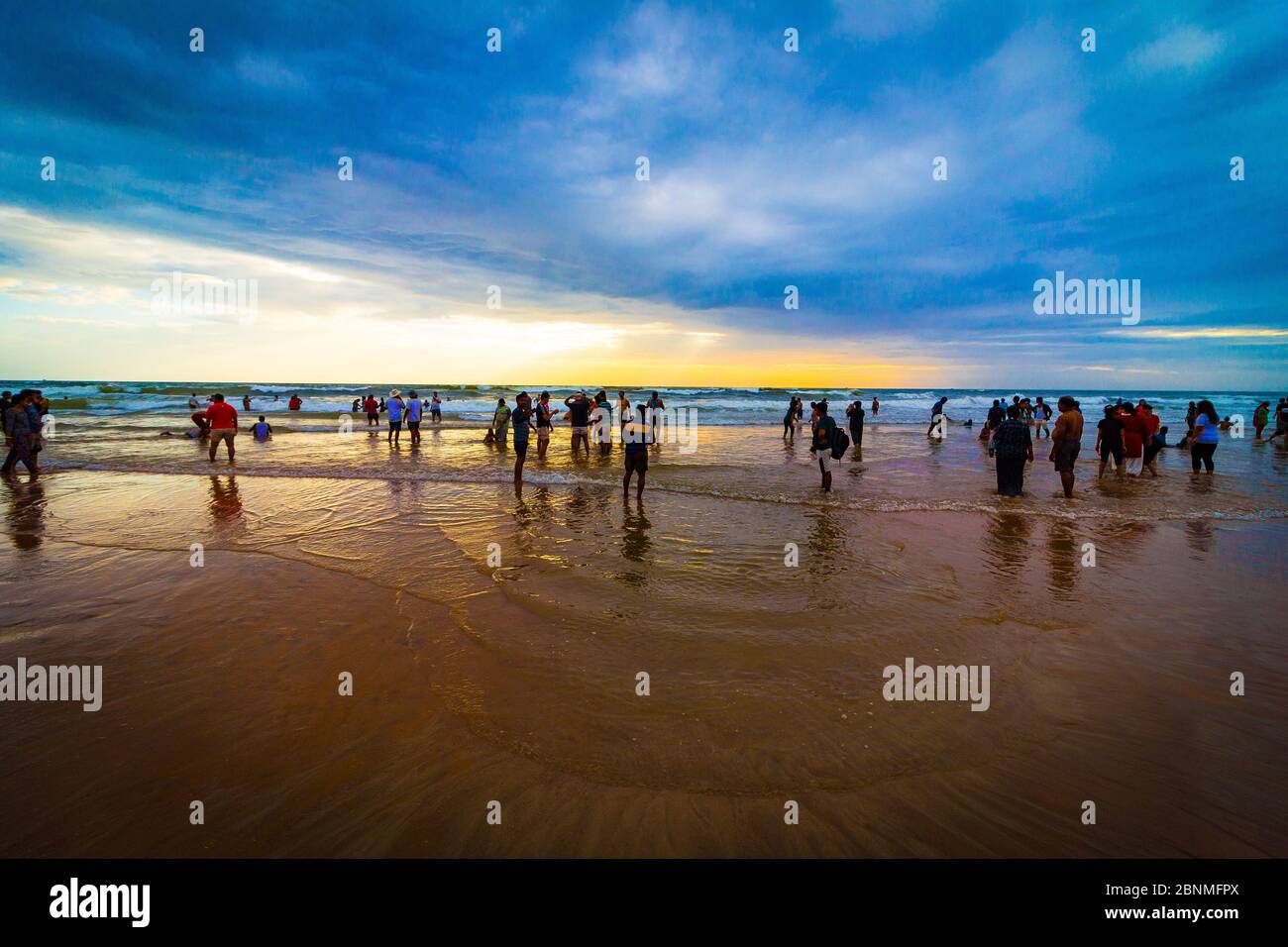 Touristen genießen den Sand, das Meer und den Sonnenuntergang am Calangute Beach. Goas größter und zweifellos Kette von goldenen Sandstrand in Goa, Indien. Stockfoto