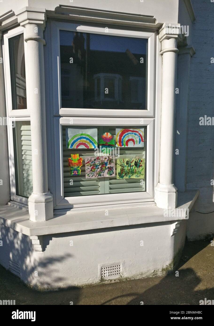 London, Großbritannien - 15. April 2020: Handgezeichneter Regenbogen und Poster mit Dankesschreiben an NHS und wichtige Arbeiter, die im Haus in Lewisham ausgestellt sind Stockfoto