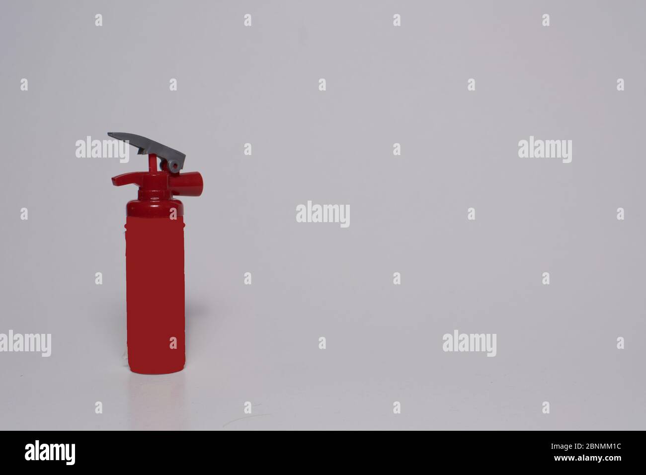 Roter Spielzeugfeuerlöscher auf weißem Hintergrund. Basteln zu Hause Stockfoto