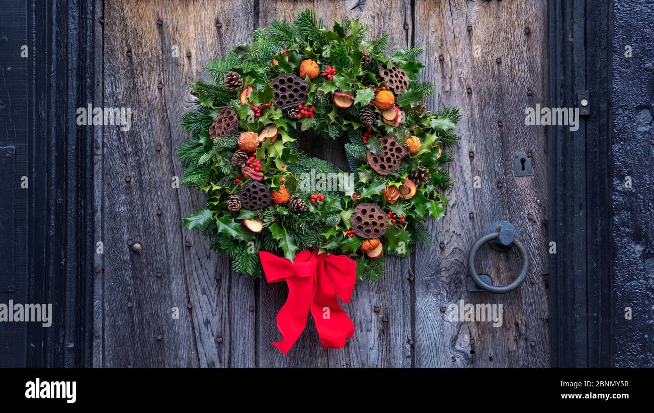 Weihnachtliche Türkranz, eine natürliche Anordnung von Blumen, Beeren,  Früchten und Blättern befestigen sich an einem Ring und setzen sich als  Dekoration an einer Haustüre auf Stockfotografie - Alamy