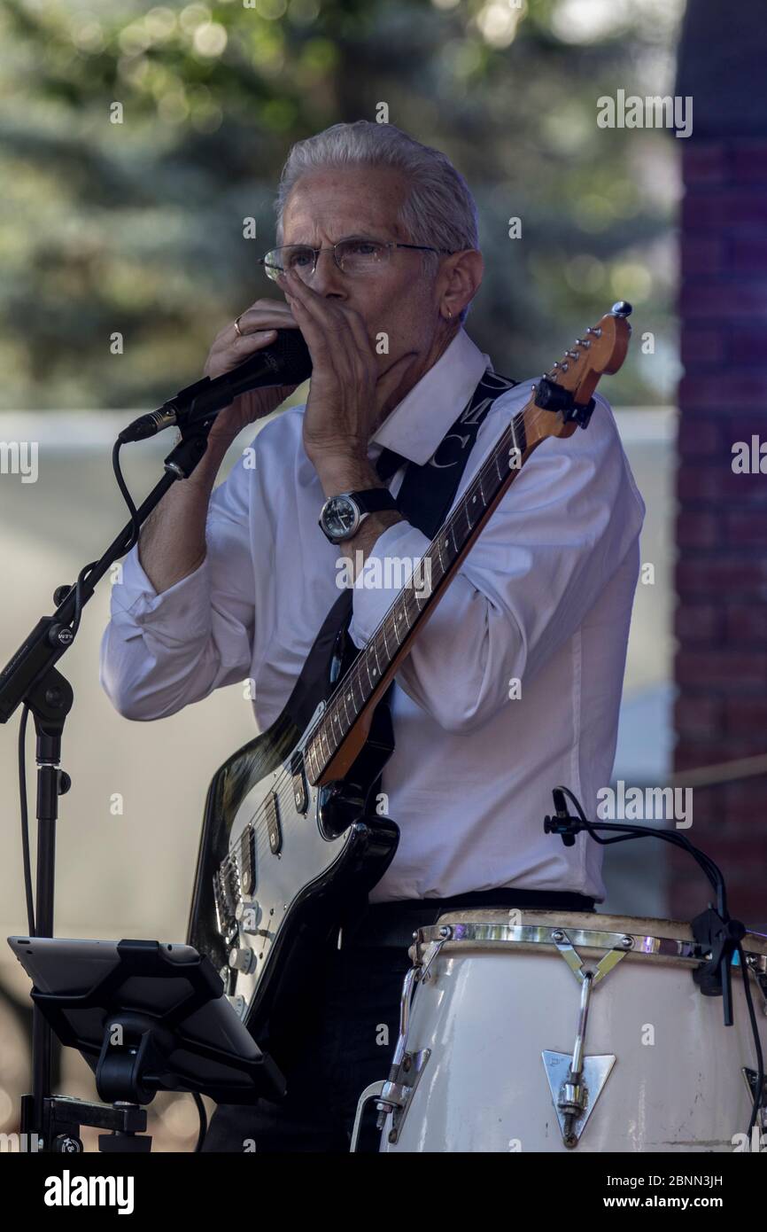 Scharf gekleideter Musiker, spielt einen Fender Statocaster, singt und im Outdoor-Konzert. Stockfoto