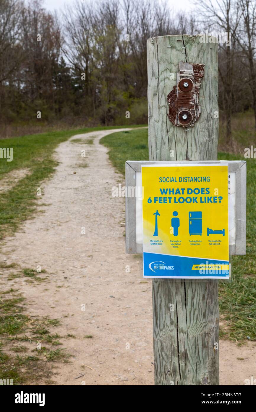 Washington Township, Michigan - EIN Schild an einem Wegweiser in Stony Creek Metropark erinnert Wanderer daran, die richtige soziale Distanz zu bleiben während der c Stockfoto