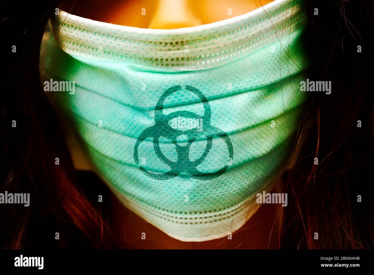 Fotomontage, Frau mit Gesichtsmaske und Biohazard-Schild, symbolisches Foto Corona-Virus Stockfoto