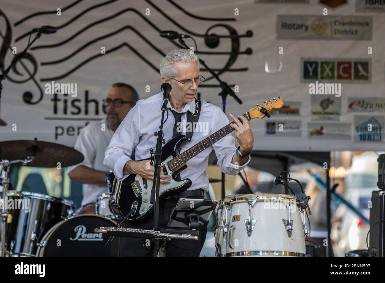 Scharf gekleideter Musiker, spielt einen Fender Statocaster, singt und im Outdoor-Konzert. Stockfoto