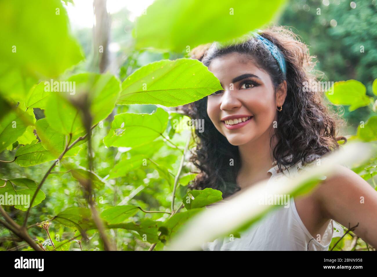 Hübsches Mädchen in der Natur, das die Kamera mit einem friedlichen Ausdruck anschaut. Stockfoto