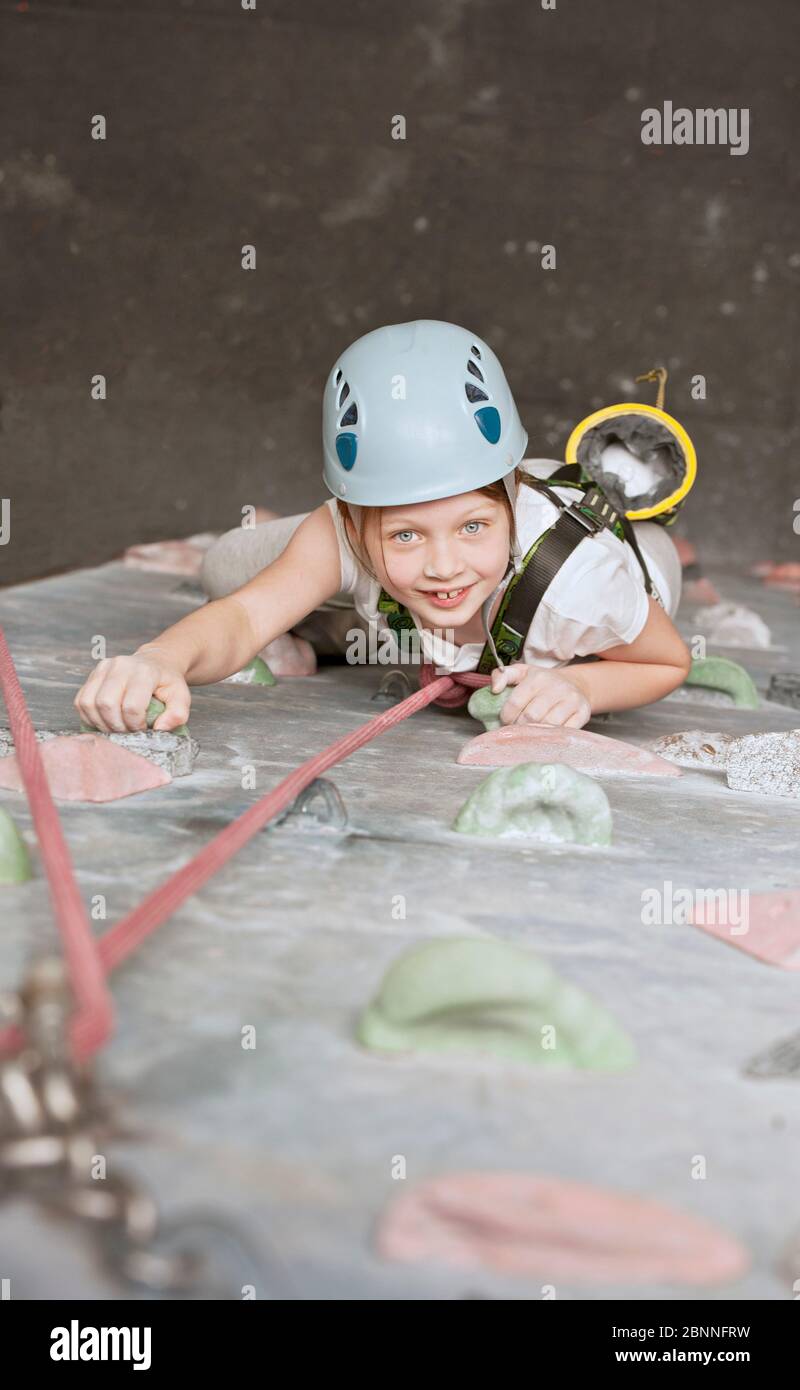 Junges Mädchen klettern an Indoor Kletterwand in England / VEREINIGTES KÖNIGREICH Stockfoto