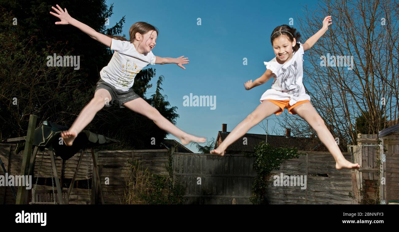 Zwei junge Mädchen springen auf Trampolin in Woking - England Stockfoto