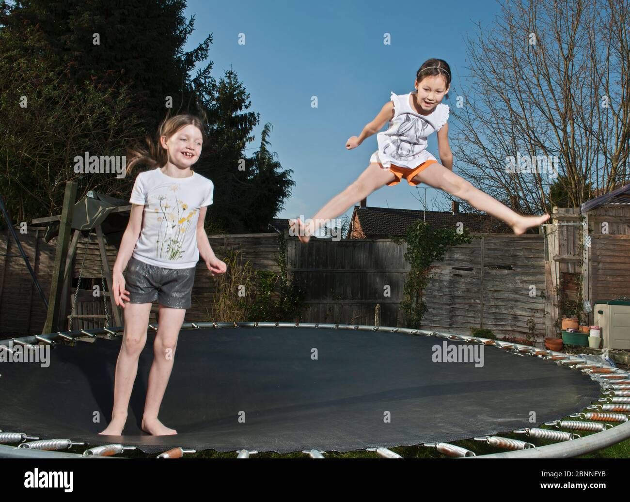 Zwei junge Mädchen springen auf Trampolin in Woking - England Stockfoto