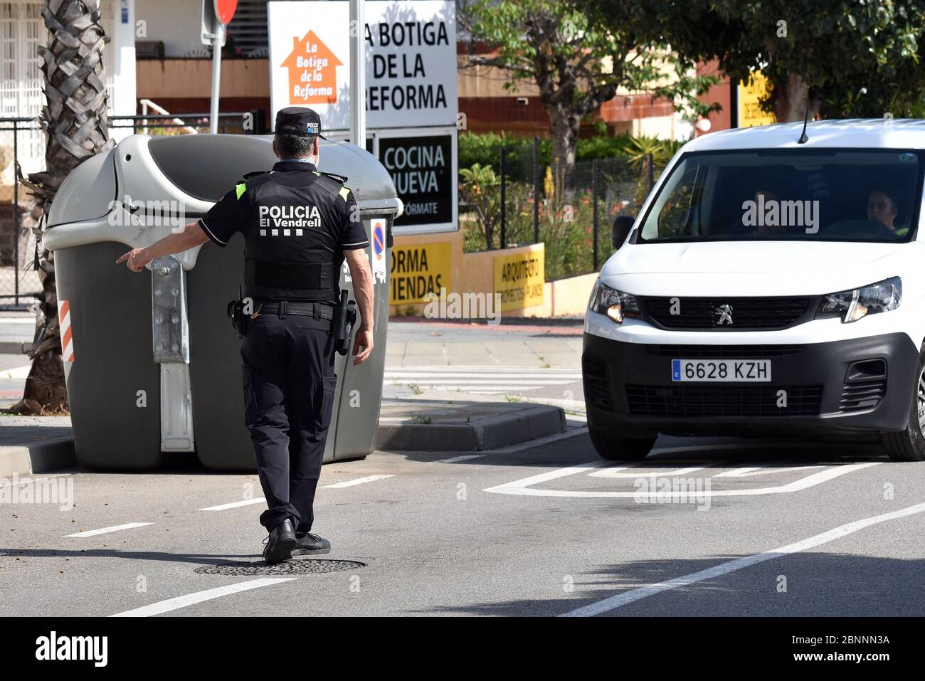 Vendrell, Spanien. April 2020. Ein Polizist mit einer Operationsmaske hält ein Fahrzeug an einem Mobilitätskontrollpunkt an.die örtliche Polizei von Vendrell führt auf der Straße eine Mobilitätskontrolle durch, um sicherzustellen, dass die Menschen nicht in ihre zweiten Wohnungen gelangen, was während der "Phase eins" des Endes der Haft möglich ist. Quelle: Ramon Costa/SOPA Images/ZUMA Wire/Alamy Live News Stockfoto