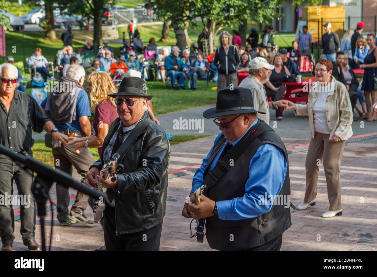 Männliche Musiker spielen beim Konzert und mischen sich mit Publikum. Stockfoto