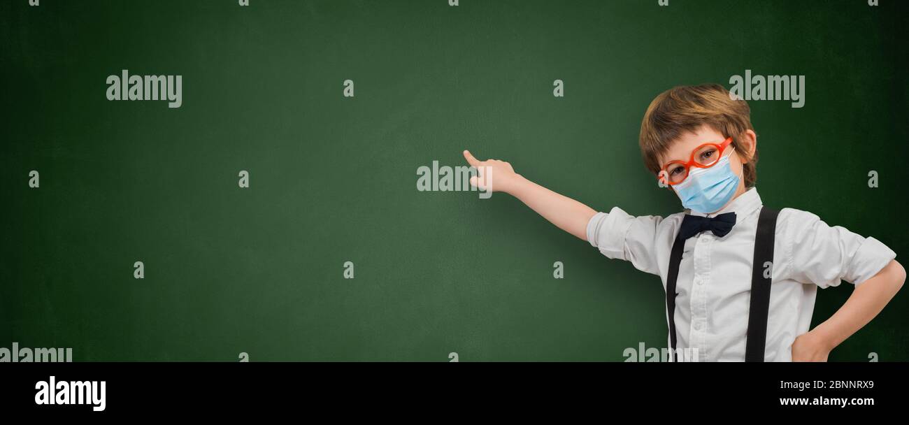 Kind mit Sanitärmaske zeigt ein leeres Whiteboard Banner Stockfoto