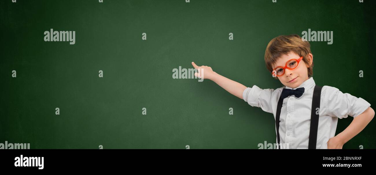 Boy zeigt mit dem Finger auf ein leeres Tafelbanner Stockfoto