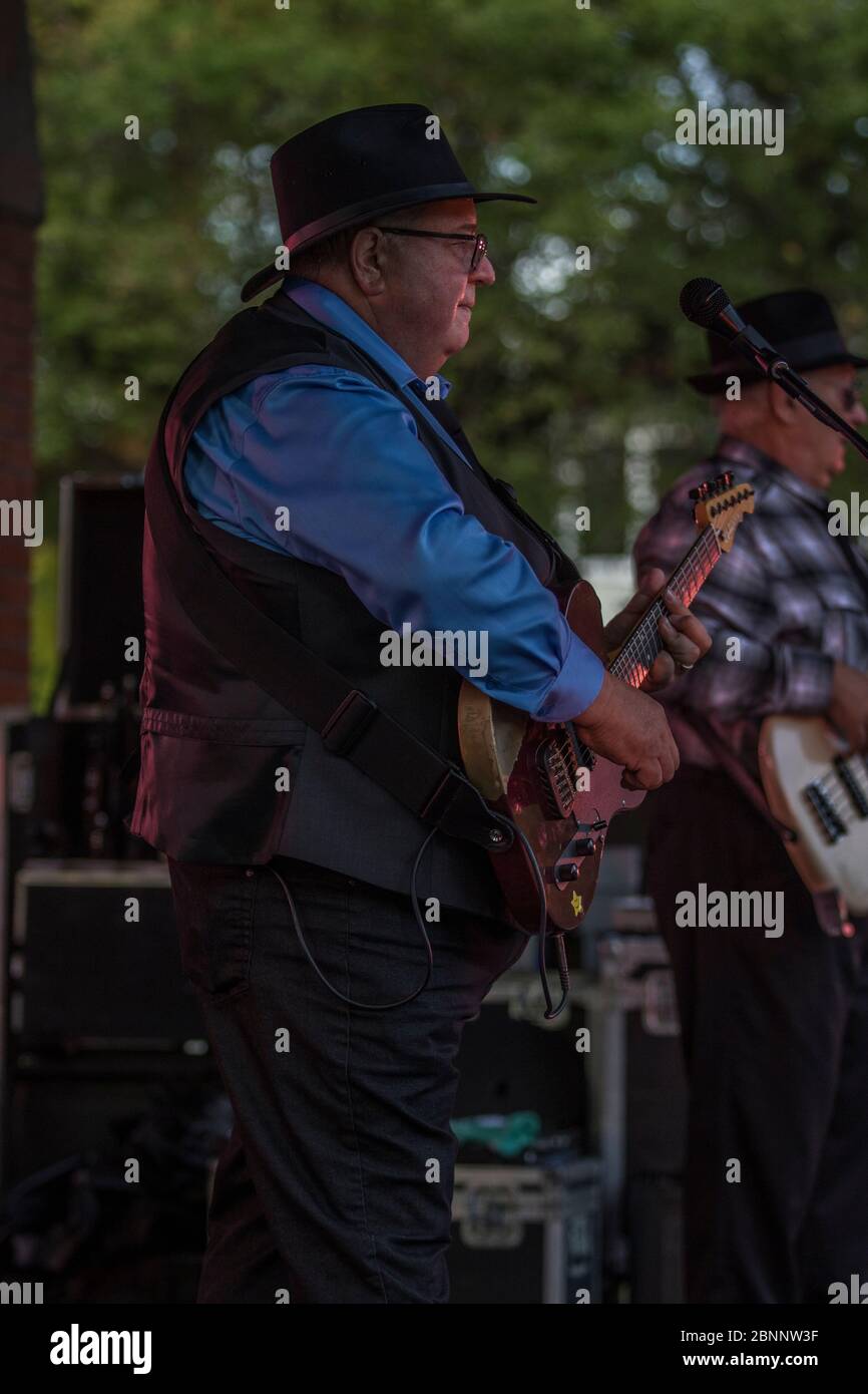 Älterer Mann spielt Leadgitarre in Rockband bei Outdoor Rock Konzert. Stockfoto