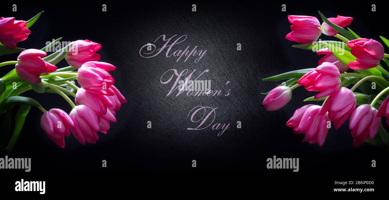 Happy Women's Day, rosa Tulpen vor schwarzem Hintergrund Stockfoto